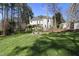 Expansive backyard with lush lawn, a stone picnic table, and a view of the home and a detached building at 1006 Henny Pl, Raleigh, NC 27614