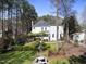 Expansive backyard featuring a lush lawn, manicured gardens, mature trees, and a charming water fountain at 1006 Henny Pl, Raleigh, NC 27614