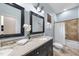 Bathroom with double vanity, framed mirrors, and tiled shower and bath with curtain at 1006 Henny Pl, Raleigh, NC 27614