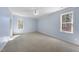 Spacious bedroom features carpet flooring, blue walls, and two large windows at 1006 Henny Pl, Raleigh, NC 27614