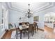 Dining room with a large chandelier, light blue walls, and wood floors at 1006 Henny Pl, Raleigh, NC 27614