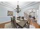 Bright dining room with light blue walls, a chandelier, and view of a staircase at 1006 Henny Pl, Raleigh, NC 27614