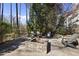 An outdoor stone patio features a stone firepit surrounded by four Adirondack chairs for backyard entertaining at 1006 Henny Pl, Raleigh, NC 27614