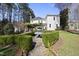 Backyard featuring a formal garden, stone fountain, and manicured hedges surrounding a gravel path at 1006 Henny Pl, Raleigh, NC 27614