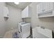 Functional laundry room with washer, dryer, storage cabinets, and a utility sink at 1006 Henny Pl, Raleigh, NC 27614