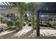 An open air stone patio with concrete flooring leads to a beautifully landscaped backyard with green space, a water fountain, and a gazebo at 1006 Henny Pl, Raleigh, NC 27614
