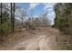 Dirt road leading to an overgrown property surrounded by dense trees at 1066 Shuford Rd, Wake Forest, NC 27587