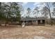 Wide exterior shot of the brick home and front yard surrounded by trees at 1066 Shuford Rd, Wake Forest, NC 27587
