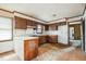Outdated kitchen with wood cabinets, peeling floor tiles, and dated countertops at 1066 Shuford Rd, Wake Forest, NC 27587