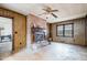 Rustic living room with brick fireplace, wood paneling, and retro ceiling fan at 1066 Shuford Rd, Wake Forest, NC 27587