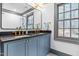 Updated bathroom features double sink vanity with black marble countertops and grey-trimmed mirror and window at 10726 Trego Trl, Raleigh, NC 27614