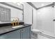 Modern bathroom featuring gray vanity with black countertop, gold fixtures, and a tiled walk-in shower at 10726 Trego Trl, Raleigh, NC 27614