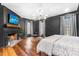 A luxurious bedroom with dark walls, a fireplace, ample natural light, and hardwood floors at 10726 Trego Trl, Raleigh, NC 27614
