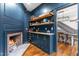 Elegant blue pantry featuring custom cabinets, open shelving, brick fireplace, and hardwood floors leading to the dining area at 10726 Trego Trl, Raleigh, NC 27614