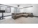 Comfortable recreation room featuring a plush gray sectional couch, large windows, and a ceiling fan at 10726 Trego Trl, Raleigh, NC 27614