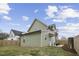 View of the home's backyard with green vinyl siding, a fenced-in area, and a small grass yard at 1105 Massey St, Smithfield, NC 27577