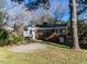 Brick home featuring a concrete patio, grassy yard, and lush foliage at 1106 Northview St, Garner, NC 27529