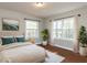 Bedroom with hardwood floors, light walls, and natural light streaming in from two windows at 1106 Northview St, Garner, NC 27529