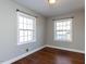 Bedroom with hardwood floors, two windows, and neutral colors at 1106 Northview St, Garner, NC 27529