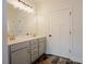 Bathroom features gray cabinetry, double sinks, tile floors, and white wall paint at 129 Edgefield Dr, Sanford, NC 27332