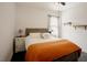 A bright bedroom offers hardwood floors, a ceiling fan, and natural light through the windows at 129 Edgefield Dr, Sanford, NC 27332