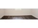 Image shows an empty room with hardwood floors, baseboard, and one small window at 129 Edgefield Dr, Sanford, NC 27332