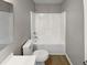 Clean bathroom featuring a shower-tub combo, new toilet and vinyl flooring at 13 Herndon Ct, Clayton, NC 27520