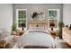 Staged main bedroom with soft decor, featuring two windows and cozy lighting at 13 Herndon Ct, Clayton, NC 27520