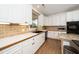 Bright kitchen with white cabinetry, black appliances, and granite countertops, offering a modern design at 1331 Langdon Pl, Pittsboro, NC 27312