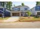 Two-story home with gray siding, brick accents, an attached garage, and a landscaped front yard at 157 Klamath Dr, Garner, NC 27529