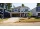 Two-story home features gray siding, brick accents, open garage and newly sodded yard at 157 Klamath Dr, Garner, NC 27529