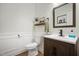 Charming powder room with a decorative mirror, elegant wallpaper, and a modern sink at 170 Blande Dr, Kenly, NC 27542