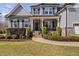 Inviting front porch with brick stairs, black railings, and lush landscaping surrounding the entrance at 1726 River Club Way, Franklinton, NC 27525