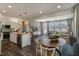 Open-concept kitchen with island, stainless steel appliances, adjacent to a dining area with a round table and modern chairs at 180 Kobus Ct, Garner, NC 27529