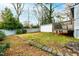 Green backyard featuring a shed, wood deck, mature trees, rock lined borders and sunny blue skies at 1817 Rankin St, Raleigh, NC 27604