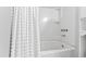 Bright bathroom with a white bathtub featuring tiled walls and an elegant white, patterned shower curtain at 1817 Rankin St, Raleigh, NC 27604