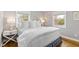 Bright bedroom with hardwood floors, white bedding, two windows and white nightstands at 1817 Rankin St, Raleigh, NC 27604