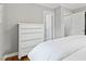Bedroom features a white dresser and white bedding with a view of the closet and door at 1817 Rankin St, Raleigh, NC 27604