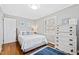 Bright bedroom features a bed with white and blue bedding, hardwood floors and dresser at 1817 Rankin St, Raleigh, NC 27604