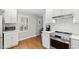 Well-lit kitchen with white cabinets, hardwood floors, and modern appliances at 1817 Rankin St, Raleigh, NC 27604