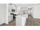 Bright, open kitchen features stainless steel appliances, gray cabinets, quartz countertop island, and hard wood flooring at 185 White Birch Ln, Angier, NC 27501