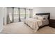 Comfortable bedroom featuring large windows, plush carpet, and a tray ceiling at 193 Millennium Dr, Pittsboro, NC 27312