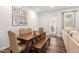 Well-lit dining room featuring a wooden table, chairs, bench and access to an outdoor patio at 193 Millennium Dr, Pittsboro, NC 27312