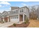 Charming gray townhome featuring a brick facade, two-car garage, and manicured landscaping at 193 Millennium Dr, Pittsboro, NC 27312