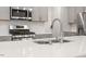 Close-up of the kitchen island with a stainless steel sink, faucet, and modern appliances at 193 Millennium Dr, Pittsboro, NC 27312