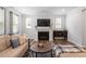 Inviting living room with a cozy sofa, elegant fireplace, and abundant natural light for relaxed living at 193 Millennium Dr, Pittsboro, NC 27312