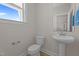 This powder room features a pedestal sink, toilet, and a decorative mirror at 20 Diamond Creek Dr, Zebulon, NC 27597