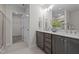 Bright bathroom with double sinks, gray cabinets, white countertops and a walk in closet at 20 Diamond Creek Dr, Zebulon, NC 27597