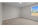 Neutral bedroom with light carpet; window overlooks open grassy area at 20 Diamond Creek Dr, Zebulon, NC 27597