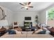 Bright living room with ceiling fan, dark wood floors, a comfortable sofa and stylish modern furniture at 20 Diamond Creek Dr, Zebulon, NC 27597
